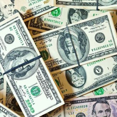 Dólar avança, mas permanece próximo das mínimas do ano com cortes de projeções