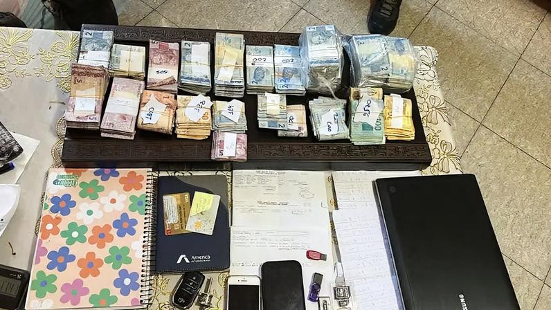 Cadernos, celulares e dinheiro apreendido pela Polícia Civil do DF, relacionados a um esquema de estelionato que movimentou R$ 1 bilhão (Foto: Reprodução)