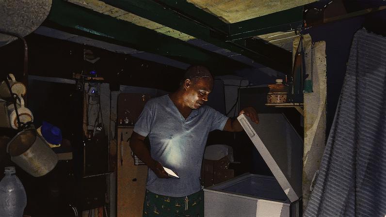 Homem usa a luz do celular para iluminar a cozinha durante apagão (Foto: Reprodução)