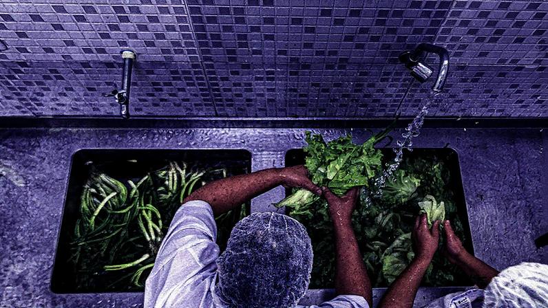 Cozinheiras lavam alimentos para doação em uma comunidade (Foto: Reprodução)