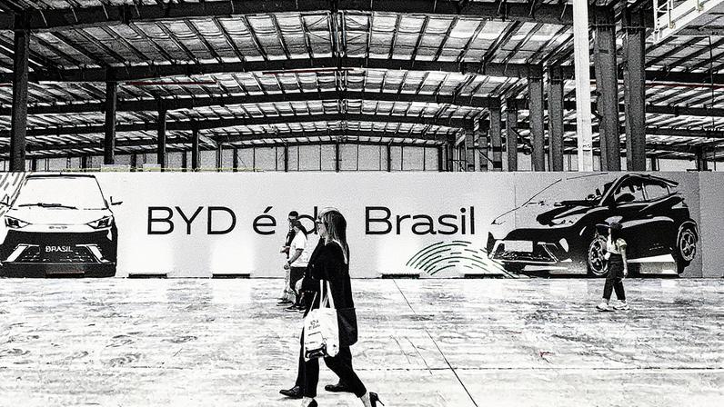 Mulher caminha na fábrica da montadora BYD em Camaçari, na Bahia (Foto: Reprodução)
