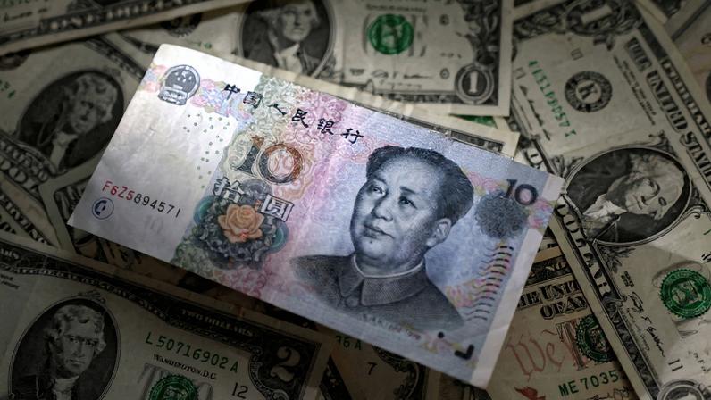 Cédulas de yuan e dólar dispostas sobre uma superfície (Foto: Reprodução)