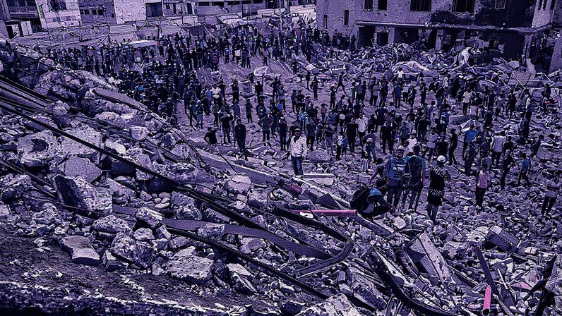 Palestinos observam os destroços do edifício Al-Ruya Tower, na Cidade de Gaza, após bombardeio (Foto: Reprodução)