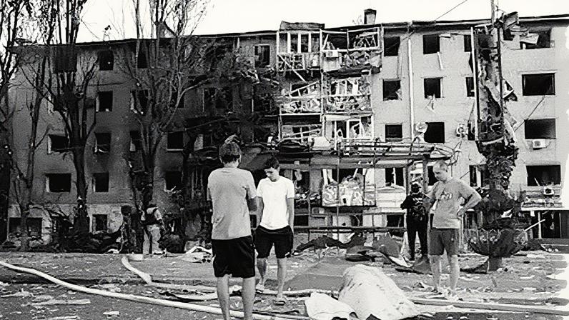 Residentes em Zaporiyia ao lado de sua casa destruída após um ataque aéreo (Foto: Reprodução)