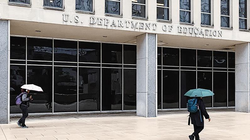 Trabalhadores saem do prédio do Departamento de Educação durante uma chuva em Washington, D.C. (Foto: Reprodução)