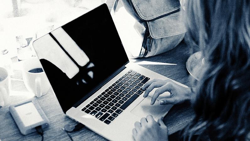 Homem trabalhando em um ambiente remoto, utilizando um laptop em uma mesa com plantas ao fundo (Foto: Reprodução)