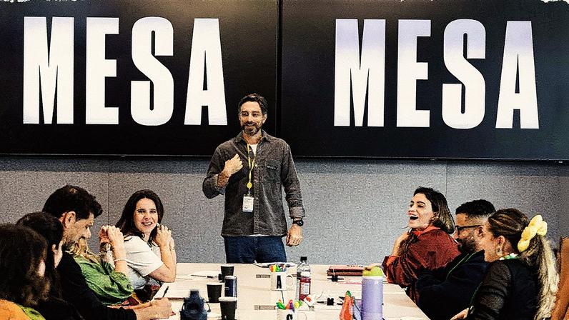 Bruno Couto, Líder de Solução, sentado na cabeceira da mesa (Foto: Reprodução)