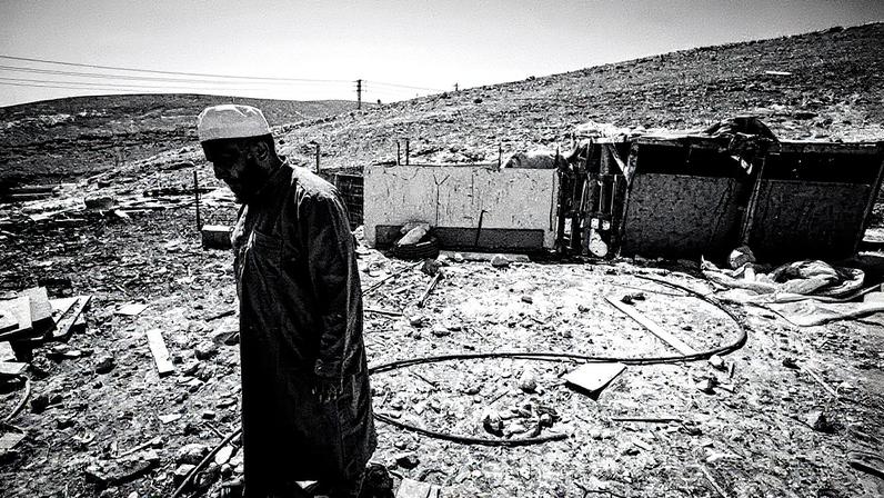 Homem alimenta seu gado em Khan al-Ahmar, na Cisjordânia (Foto: Reprodução)