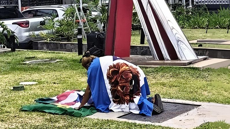 Apoiadora de Jair Bolsonaro ora sobre bandeiras do Brasil e dos Estados Unidos em frente ao hospital DF Star (Foto: Reprodução)