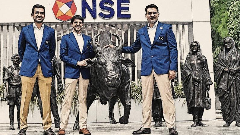 Executivos da Urban Company Limited posam para foto perto da estátua do touro antes da cerimônia de listagem de sua Oferta Pública Inicial (IPO) na Bolsa Nacional de Valores (NSE) em Mumbai (Foto: Reprodução)