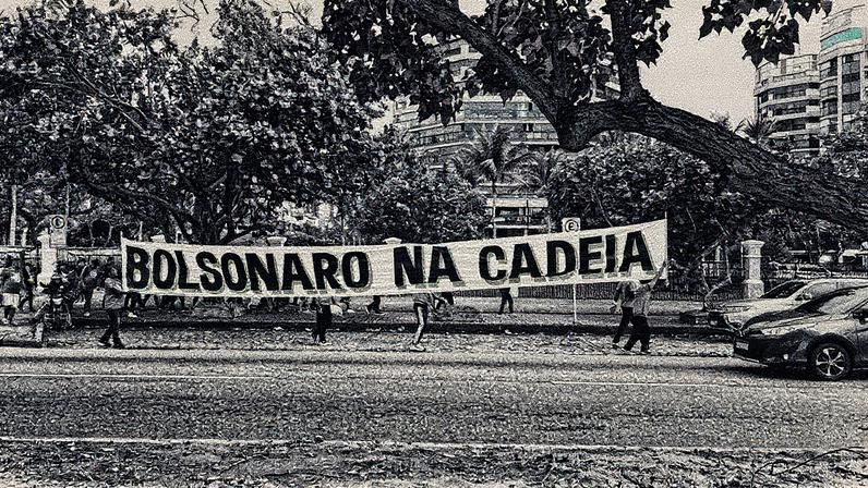 Manifestantes seguram cartaz em frente ao condomínio de Bolsonaro (Foto: Reprodução)