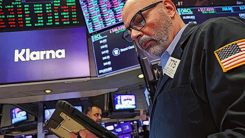 Traders trabalham no pregão enquanto uma tela exibe o logotipo da fintech sueca Klarna durante a IPO da empresa na Bolsa de Valores de Nova York (Foto: Reprodução)