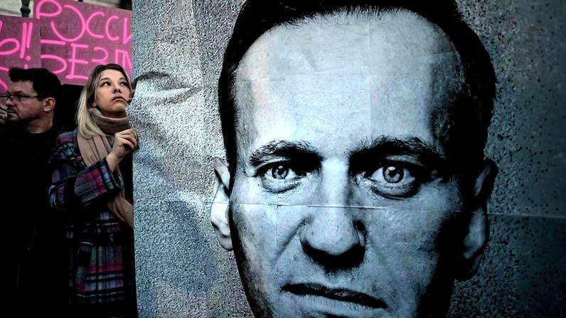 Manifestante segura imagem do oposicionista Alexey Navalny durante protesto em Varsóvia (Foto: Reprodução)