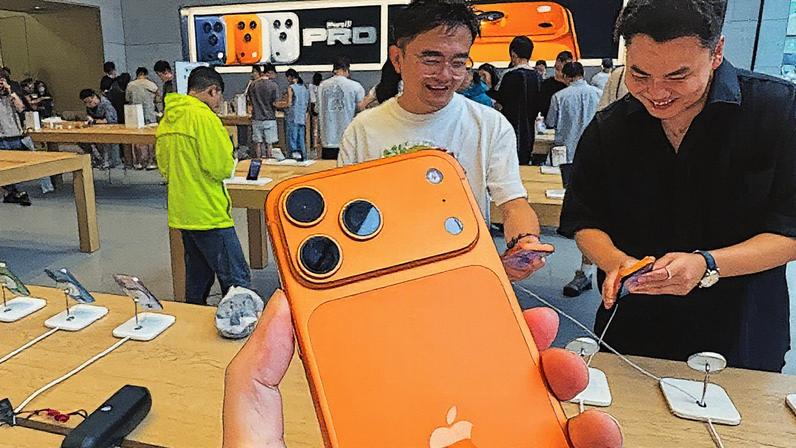 Cliente segura o novo smartphone iPhone 17 Pro Max na cor laranja dentro de uma loja da Apple em Chongqing, China (Foto: Reprodução)