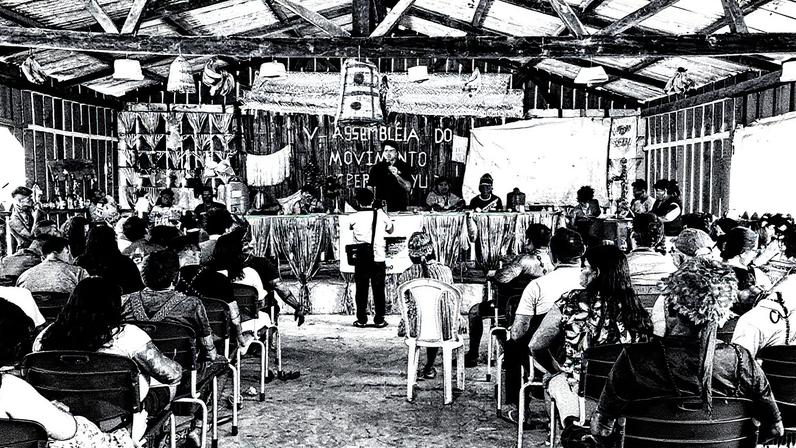 Assembleia dos Munduruku com participantes em círculo, discutindo em um ambiente ao ar livre (Foto: Reprodução)