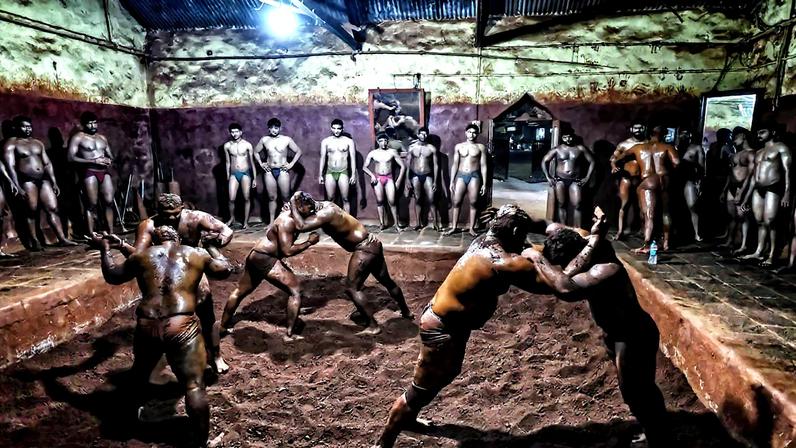 Seis lutadores cobertos de barro praticam no talim Gangavesh (Foto: Reprodução)