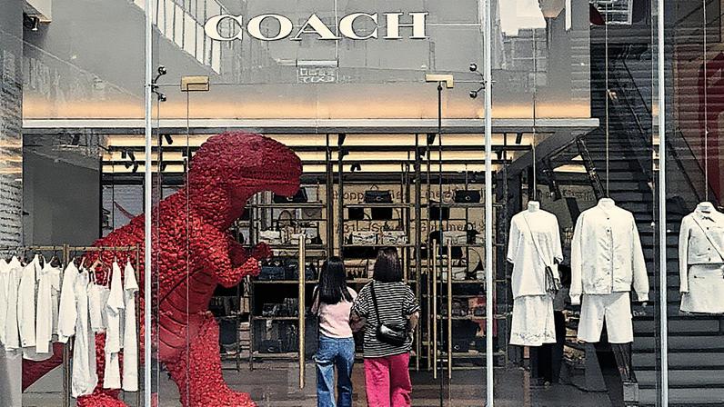 Pessoas visitam a loja da marca de luxo Coach em um shopping em Pequim (Foto: Reprodução)