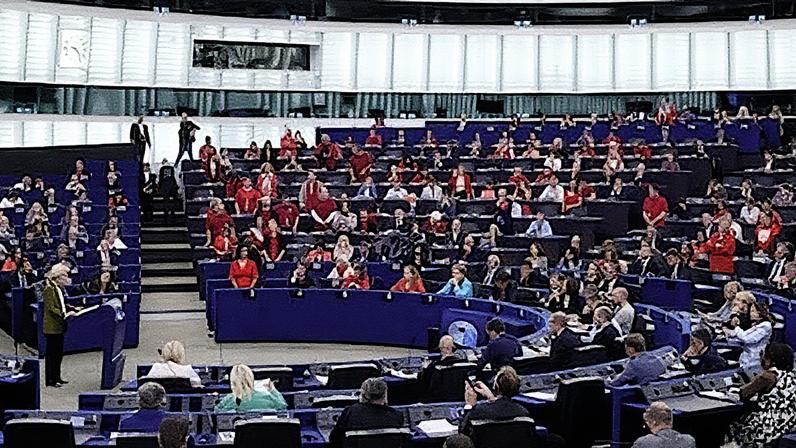Ursula von der Leyen, presidenta da Comissão Europeia, fala no Parlamento Europeu, onde vários deputados estão vestidos de vermelho em protesto pelo asedio a Gaza (Foto: Reprodução)