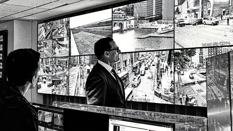 Agente especial do Serviço Secreto dos EUA observa painel de câmeras de segurança em escritórios de Nova York (Foto: Reprodução)