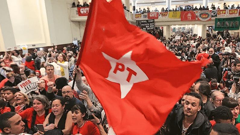 Militantes do PT seguram bandeira durante evento político (Foto: Reprodução)