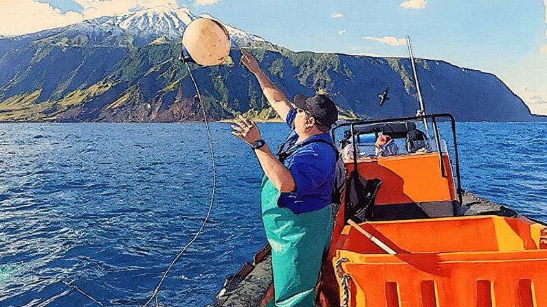 Julia Gunther Rodney Green throws a buoy overboard to mark the location of a trap during a lobster tagging operation on Tristan da Cunha in the South Atlantic Ocean (Credit: Julia Gunther)