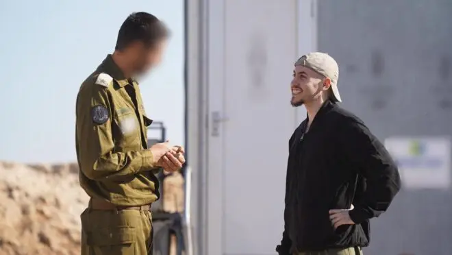 Uma foto divulgada pela Assessoria de Imprensa do Governo de Israel mostra um representante do exército israelense na base militar israelense de Re"im falando com Eitan Mor, um dos reféns libertados pelo Hamas nesta segunda (13) (Foto: EFE/EPA/ASSEMBLEIA DE IMPRENSA DO GOVERNO DE ISRAEL)