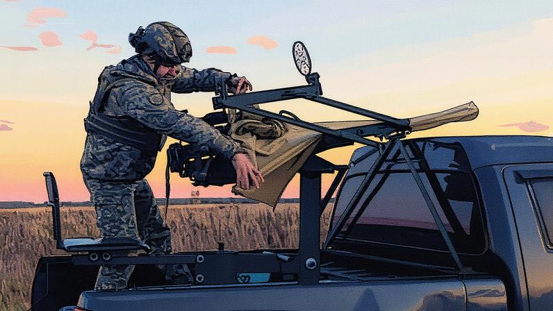 A Ukrainian soldier removes the cover from a heavy machine gun used for shooting down Russian drones.