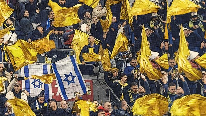 Maccabi supporters wave yellow flags next to Israeli flags during a game. Photograph: Robin van Lonkhuijsen/ANP/AFP/Getty Images