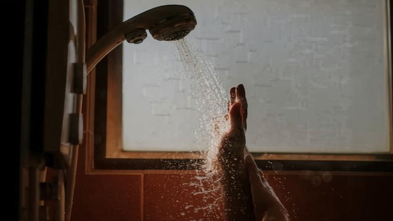 hands being held up to the water in a shower