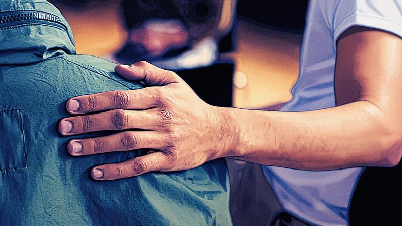 An emergency service psychologist speaks to a resident as she looks at her apartment building that was damaged in an overnight Russian drone attack in Kyiv.