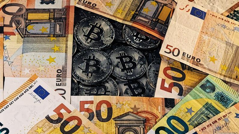 Representaçãoes da moeda virtual Bitcoin e de notas de euro em imagem ilustrativa