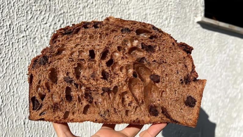 Panetone de chocolate brasileiro tem massa escura com lascas de chocolate e cobertura de farinha de amêndoas e avelã • Divulgação