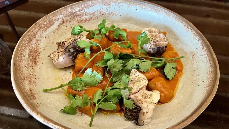Nhoque braseado, com massa feita de banana pacovan, creme de moqueca e pedaços de peixe escalfado