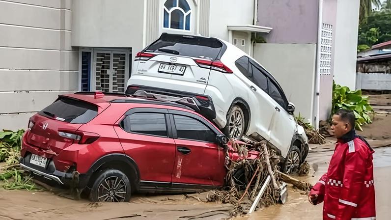Cars lie piled up after flash flooding from monsoon rains in the Lubuk Minturun area of Padang City, West Sumatra.
