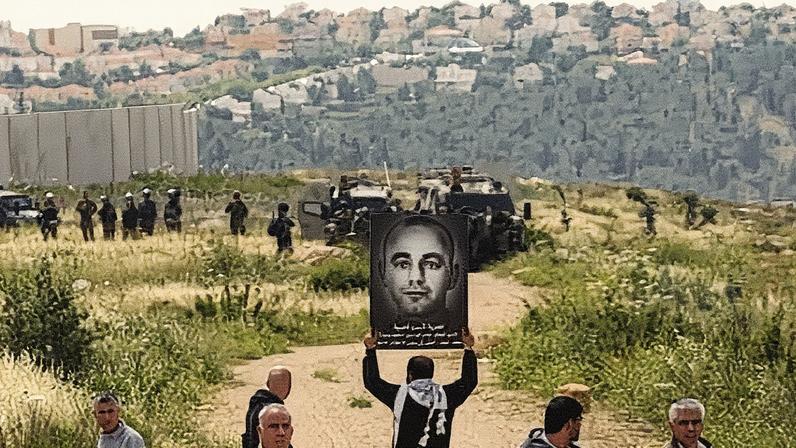A Palestinian protester holds a placard in 2015 bearing a portrait of Nasser Abu Srour during a demonstration marking Palestinian Prisoner Day in the West Bank town of Bilin, near Ramallah. Photograph: Abbas Momani/AFP/Getty Images