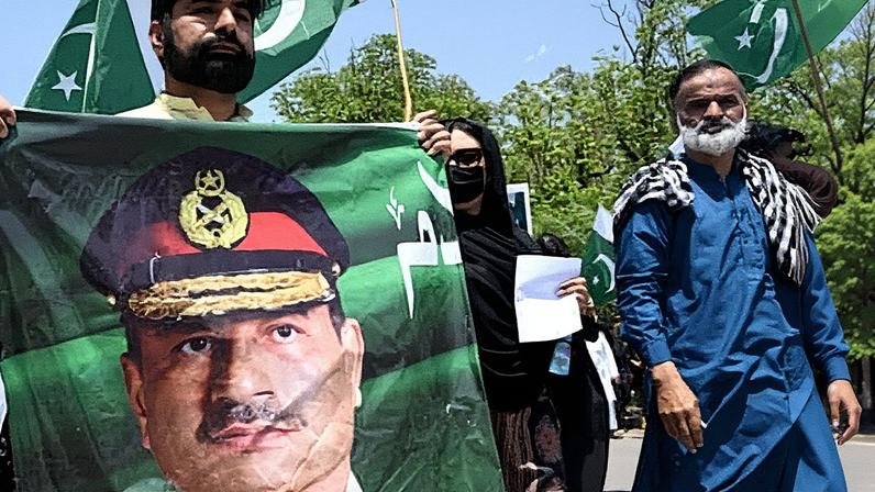 An attender at a rally in Islamabad in May supporting Pakistan’s armed forces carries a banner depicting Field Marshal Asim Munir. Photograph: Aamir Qureshi/AFP/Getty Images