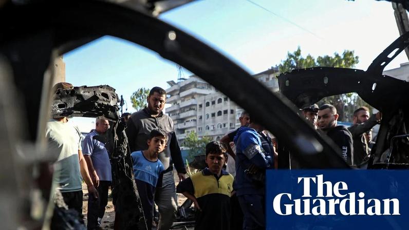 Palestinians gather around a destroyed vehicle west of Gaza City.