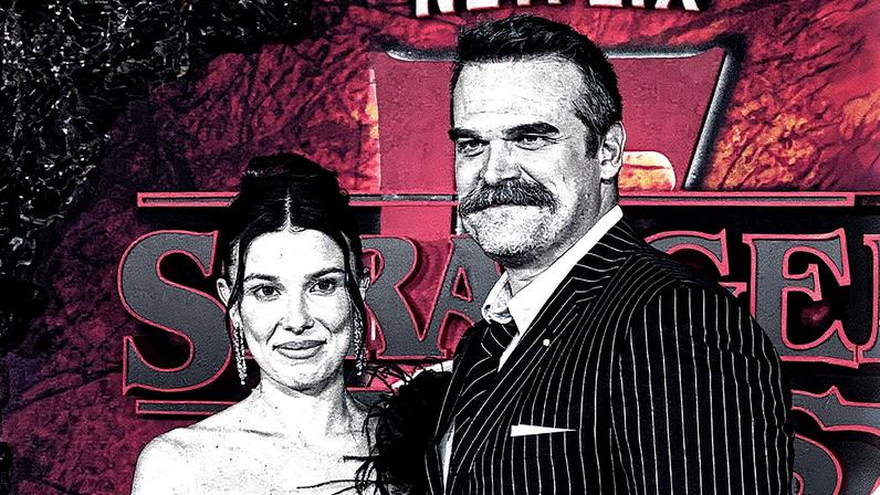 Millie Bobby Brown surge sorridente ao lado de David Harbour — Foto: Getty Images