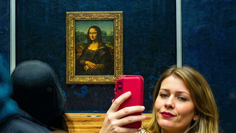 Snap happy: a visitor takes a selfie on their phone of in front of Leonardo da Vincis Mona Lisa (around 1503) Photo: Barry Talley (Unsplash)