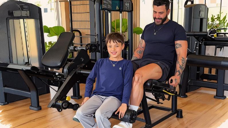 Gusttavo Lima usa filho como peso para treinar em academia — Foto: Reprodução/Instagram