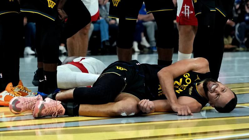 Stephen Curry deitado com dores em jogo entre Warriors e Rockets na NBA (Foto: Thearon W. Henderson/Getty Images/AFP)