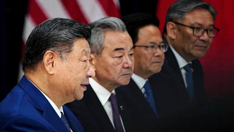 Chinese President Xi Jinping, flanked by Chinese Foreign Minister Wang Yi, speaks during a bilateral meeting with U.S. President Donald Trump in Busan, South Korea.