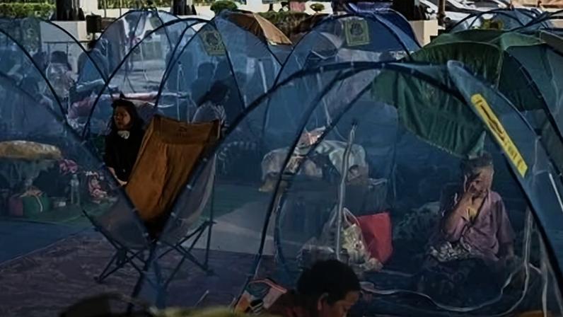 Moradores deslocados descansam enquanto se abrigam em um centro de evacuação durante confrontos ao longo da fronteira entre a Tailândia e o Camboja, na província tailandesa de Sa Kaeo, em 10 de dezembro de 2025. Foto: Lillian SUWANRUMPHA / AFP
