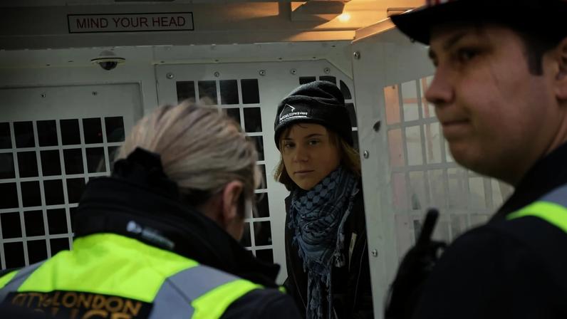 A handout photograph taken on and released by Prisoners for Palestine in London on December 23, 2025 shows Swedish activist Greta Thunberg sitting in a police van following her arrest by Police officers outside the offices of Aspen Insurance at Plantation Place on Fenchurch Street. London police on Tuesday arrested Swedish activist Greta Thunberg at a demonstration in support of pro-Palestinian hunger strikers, Palestinian activist groups said. "Greta Thunberg was arrested under the Terrorism Act at the Prisoners for Palestine lock-on protest," Prisoners for Palestine said in a statement. (Photo by Prisoners for Palestine / AFP) / RESTRICTED TO EDITORIAL USE - MANDATORY CREDIT "AFP PHOTO / Prisoners for Palestine / HANDOUT " - NO MARKETING NO ADVERTISING CAMPAIGNS - DISTRIBUTED AS A SERVICE TO CLIENTS