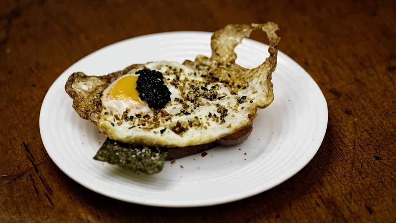 Entrada de pão com ovo e caviar (brioche tostado, ovo estrelado e caviar) do restaurante Torto Cozinha, localizado na rua Ribeiro de Barros
