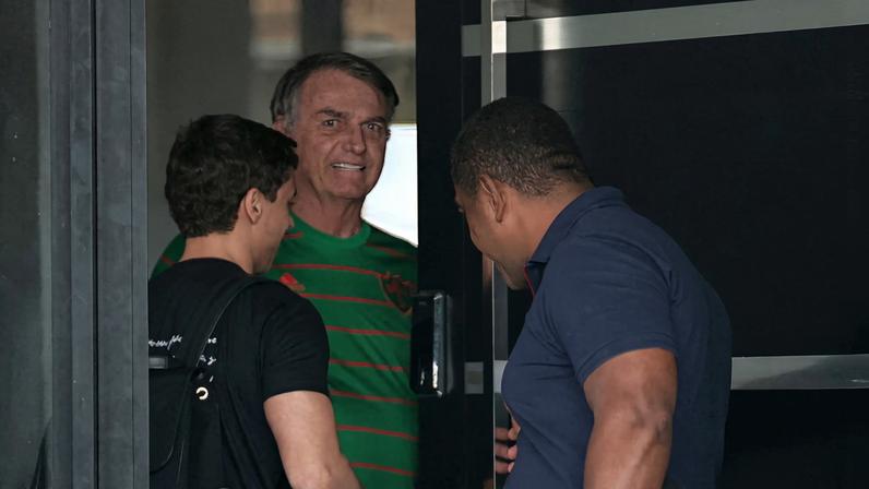 O ex-presidente do Brasil, Jair Bolsonaro, aparece na porta de sua casa, durante sua prisão domiciliar, em Brasília, Brasil, em 21 de novembro. — Foto: Mateus Bonomi/Reuters