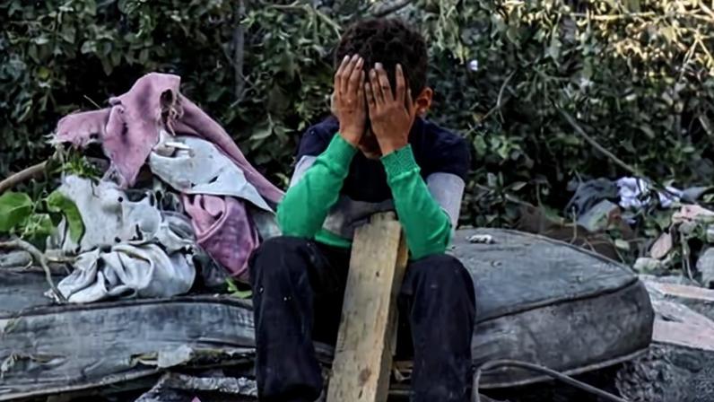A boy sits slumped amid the rubble in Nuseirat, central Gaza, after an overnight Israeli airstrike on 29 October in which at least 50 Palestinians died.