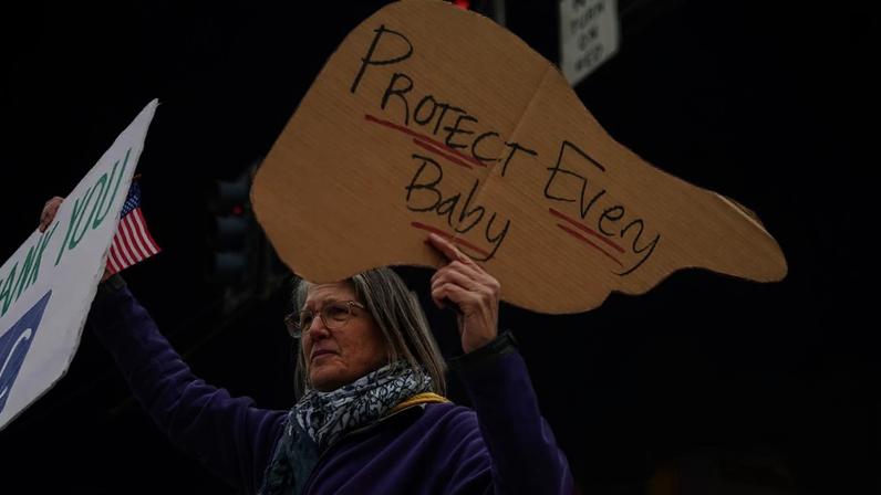 A supporter of the CDC, with signs saying ‘Thank you CDC’ and ‘Protect every baby’ outside the agency’s headquarters in Atlanta. Photograph: Elijah Nouvelage/Getty Images
