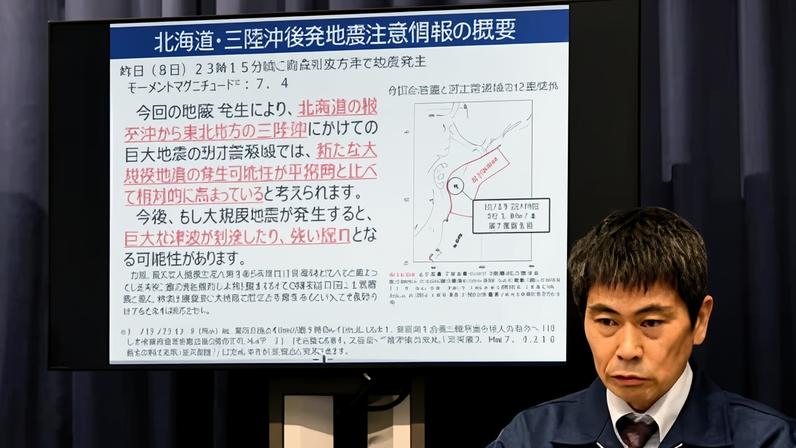 A government official speaks at a press conference on 9 December after the magnitude 7.5 earthquake struck off Japan's Pacific coast. Photograph: JIJI Press/AFP/Getty Images
