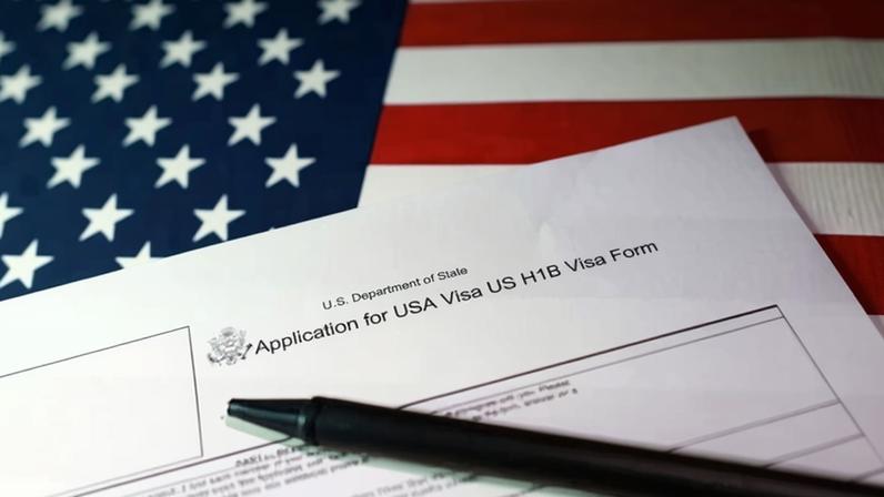 A US flag and a US H-1B visa application form on 22 September 2025. Photograph: Dado Ruvić/Reuters
